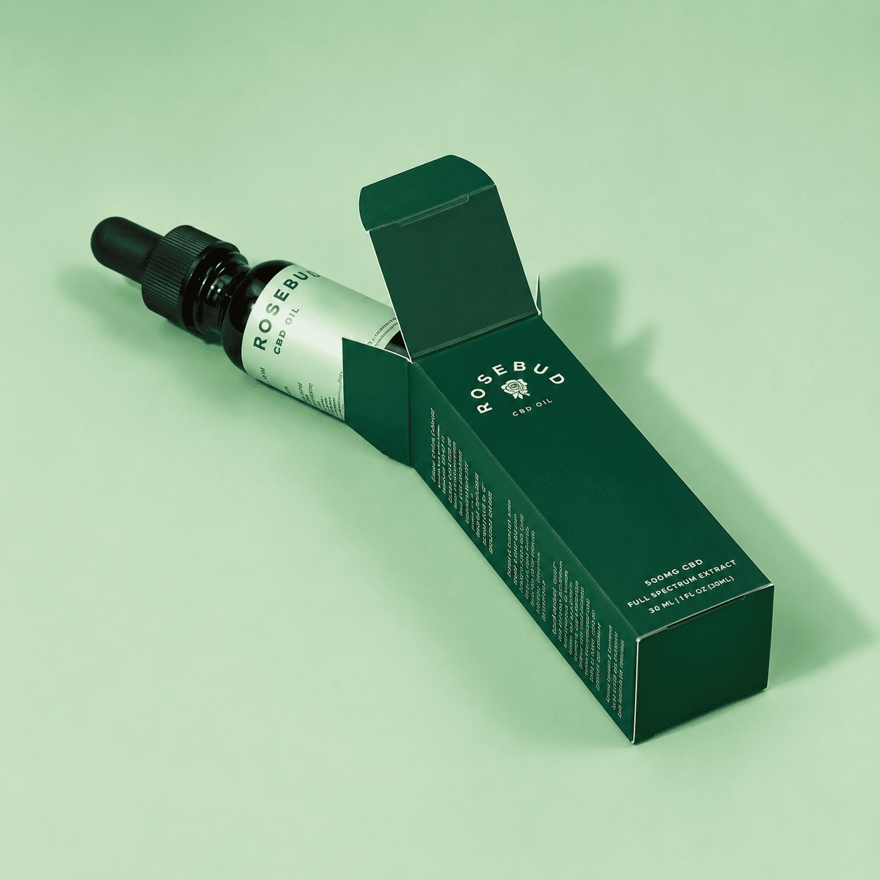 Bespoke serum boxes in deep green with a botanical logo and a matching dropper bottle for a premium skincare launch